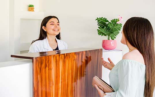 Esthéticienne qui discute avec une cliente à l'accueil de son institut