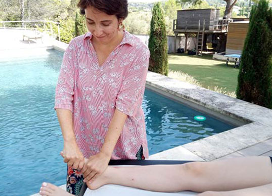 Réflexologue qui masse les pieds d'une cliente